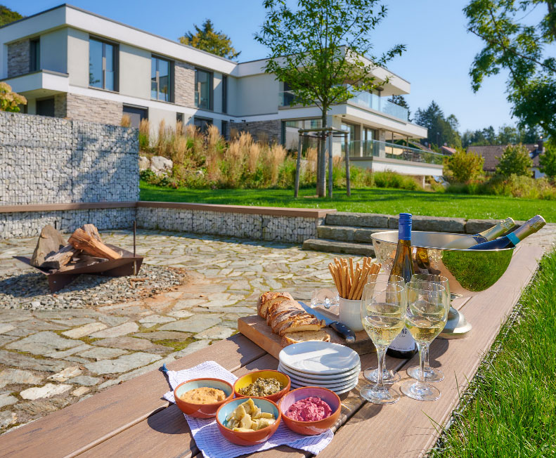 Modernes Wohnhaus mit Gabionen-Mauer und Naturstein-Terrasse — Wohnprojekt Ullrich Gärten