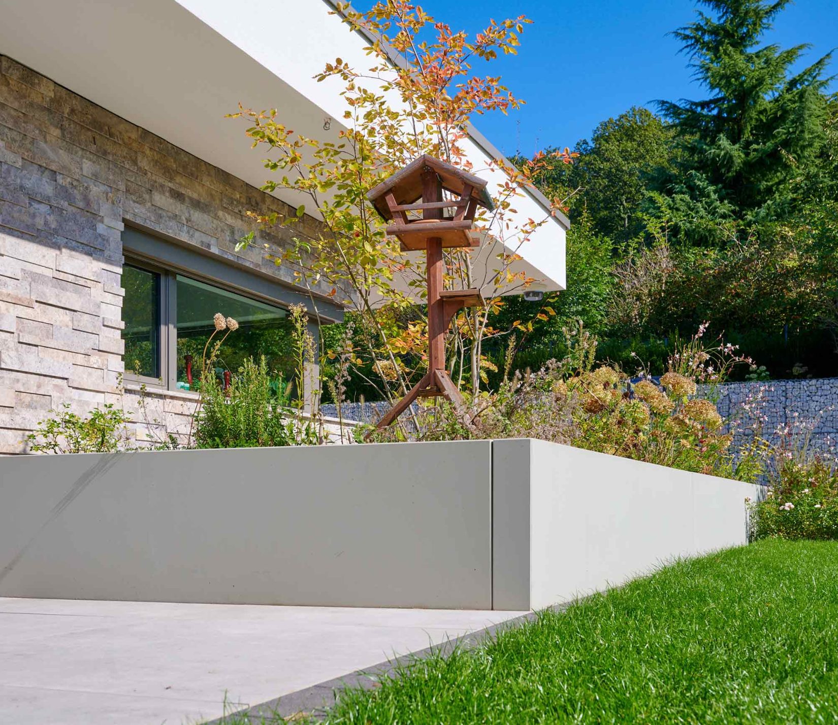 Beton-Pflanzbecken mit Vogelhäuschen und Wildblumen — Wohnprojekt Ullrich Gärten