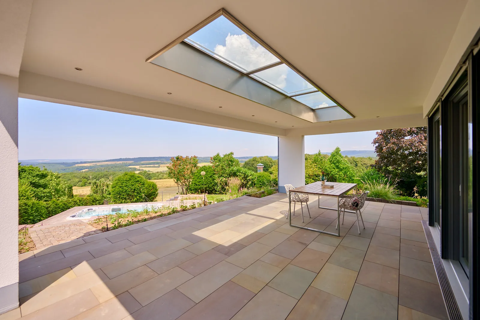 Terrassengarten: überdachte Loggia mit Weitblick ins Tal