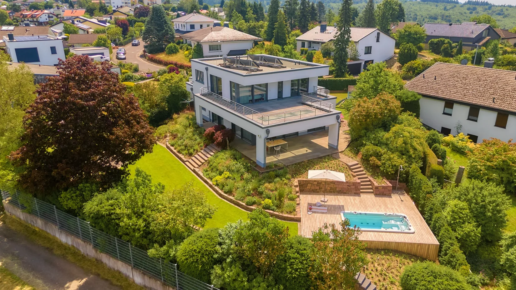 Terrassengarten: Luftaufnahme der Villa mit Natursteinterrassen und Pool