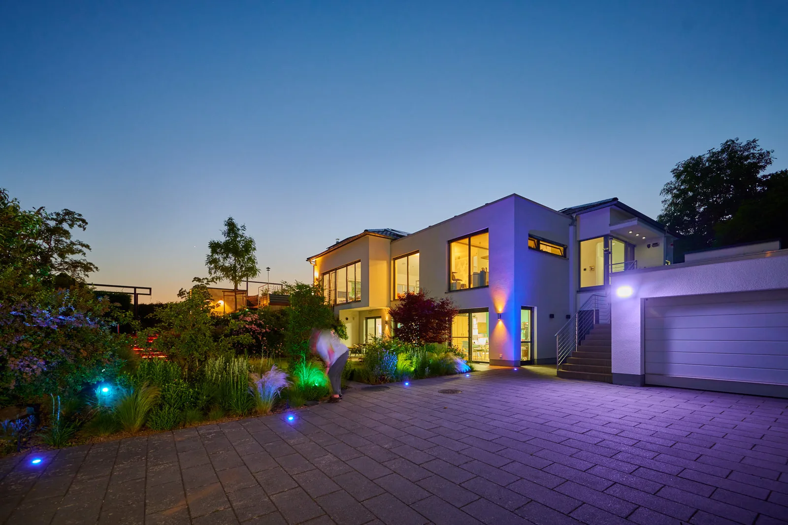 Wellnessgarten: moderne Villa illuminiert am Abend