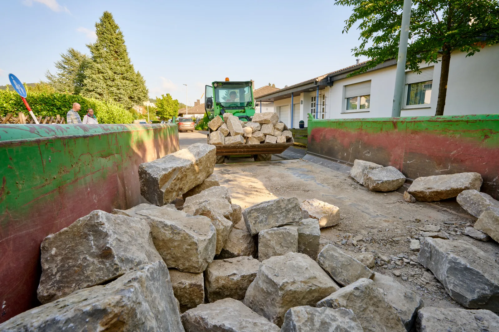 Ausführung: Baustelle mit Natursteinen und Bagger